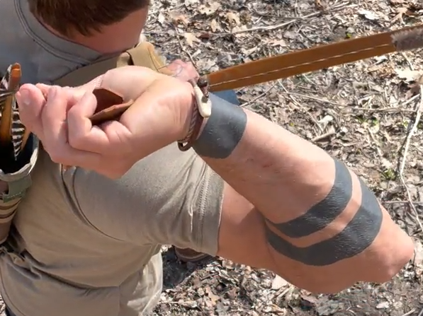 Correy drawing an arrow for his bow