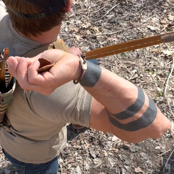 Correy drawing an arrow for his bow