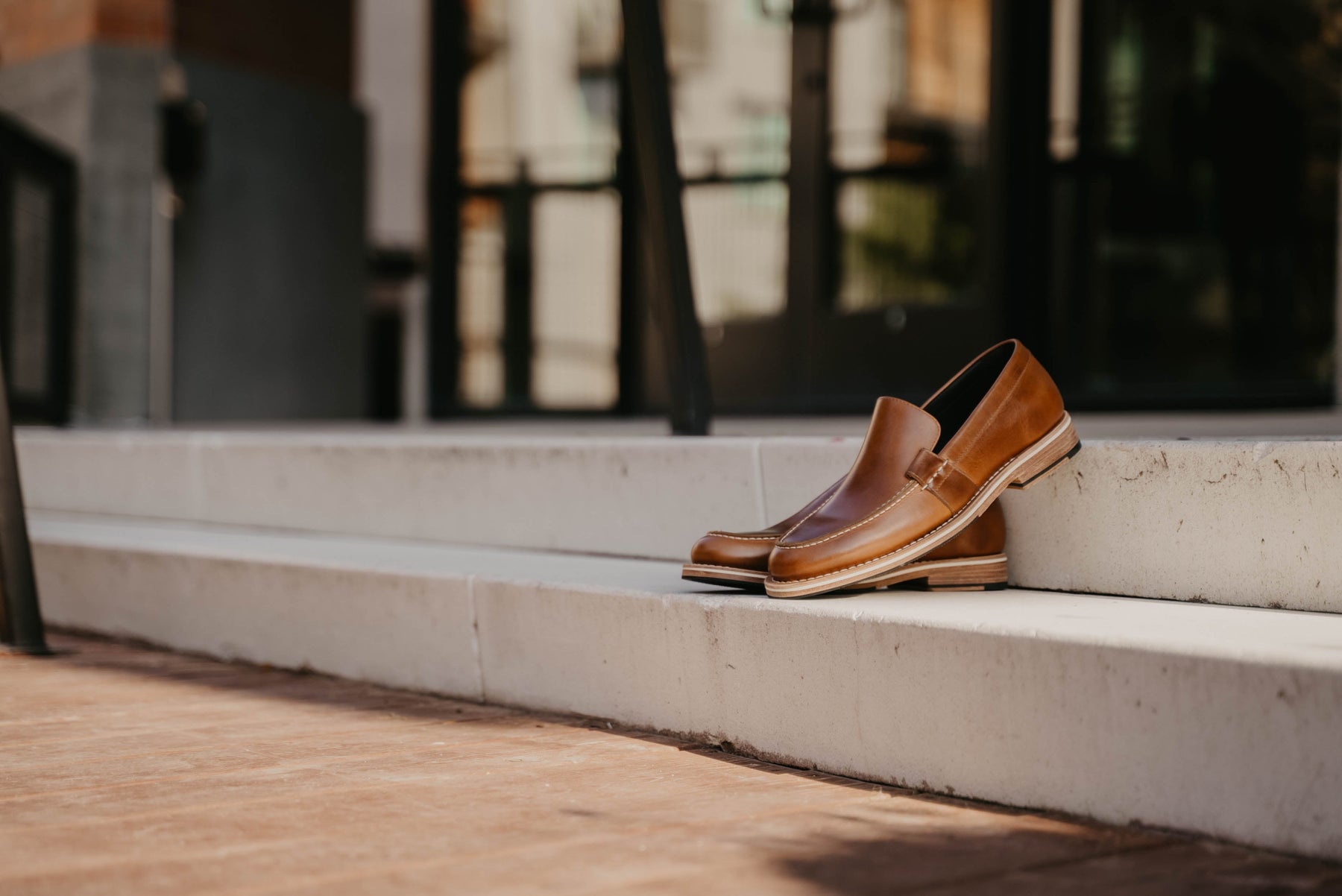 A pair of HELM Wilson leather loafers on stone steps